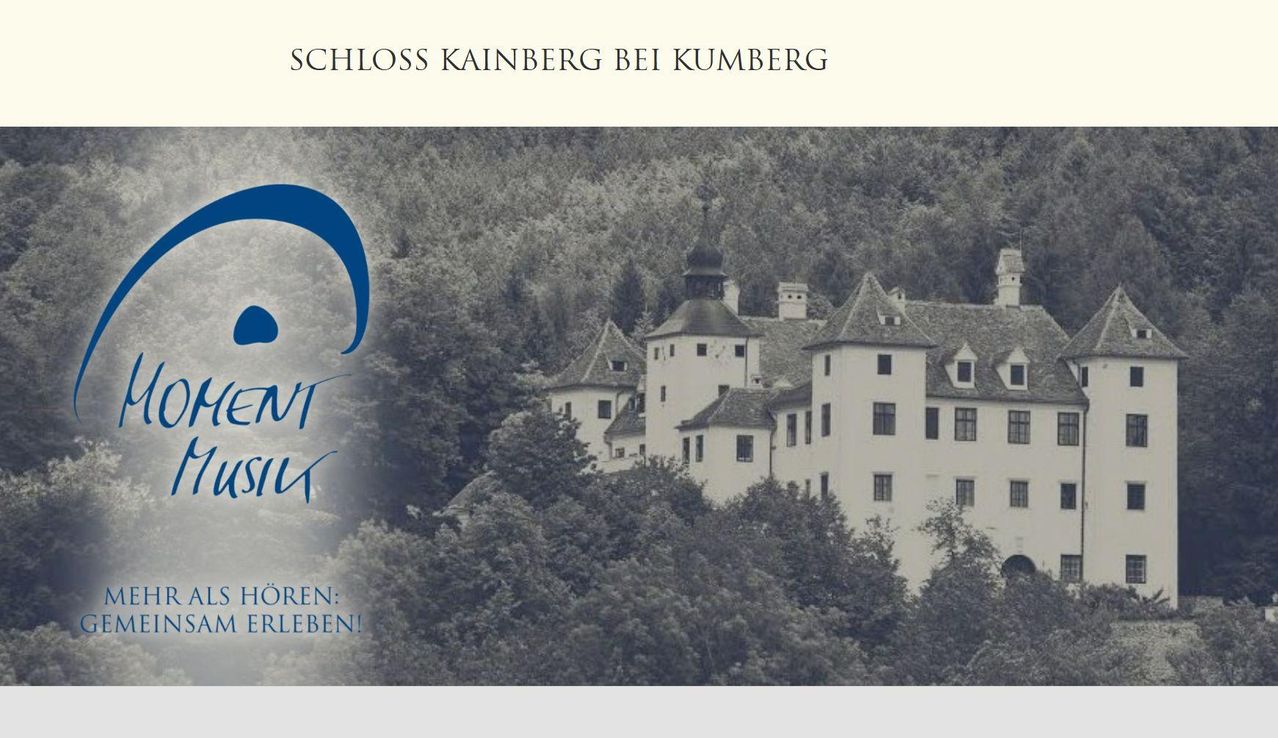 Ein Schwarz-Weiß-Foto von Schloss Kainberg bei Kumberg, einer Burg auf einem Hügel, umgeben von üppigem Grün. Die Burg hat eine Kuppel und mehrere Fenster.