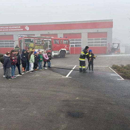 Bild enthält, Person, Fire Truck, Transportation, Truck, Vehicle, Fire Station, Jeans, Pants, Wheel, Jacket