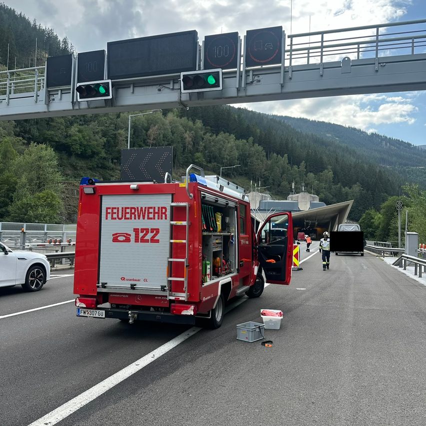 Ein Feuerwehrfahrzeug mit der Nummer 122 steht an der Seite einer Autobahn mit einer grünen Ampel darüber.