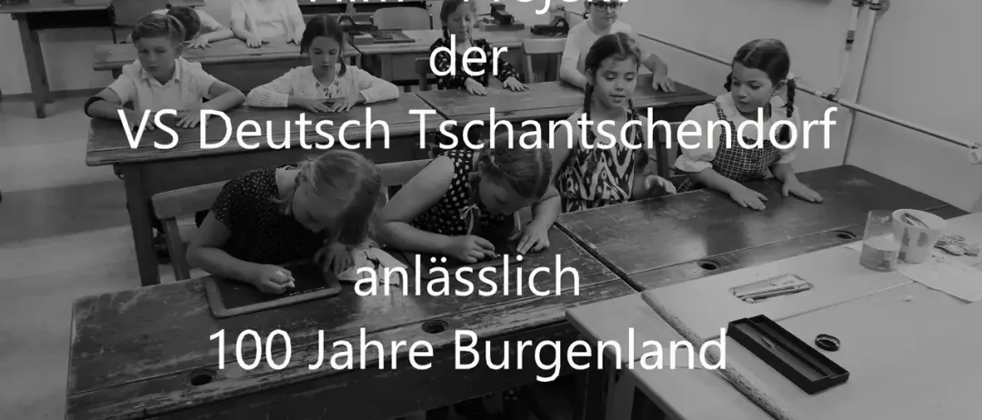 Ein Schwarz-Weiß-Foto von Kindern, die in einem Klassenzimmer an Schreibtischen sitzen, mit dem Text "Film - Projekt der VS Deutsch Tschantschendorf anlässlich 100 Jahre Burgenland".