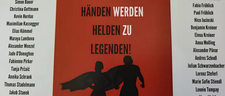 Plakat mit rotem Hintergrund, das eine Silhouette eines Mannes und einer Frau zeigt, die Händchen halten, mit dem Text 'Mit dem Abschluss in den Händen werden Helden zu Legenden!'