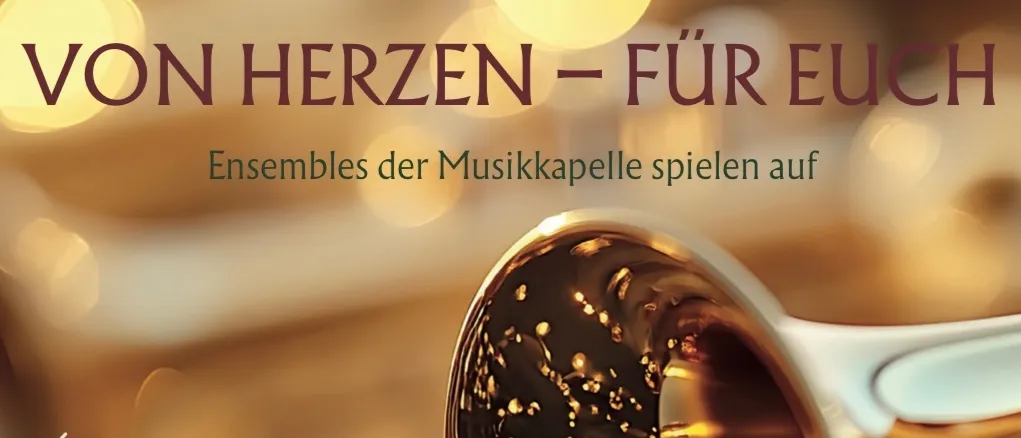 Eine goldene Trompete mit Reflexion steht im Vordergrund. Der Text lautet 'VON HERZEN - FÜR EUCH' und 'Zum Weihnachtsalbum'. Das Bild ist verschwommen mit Lichtern im Hintergrund.