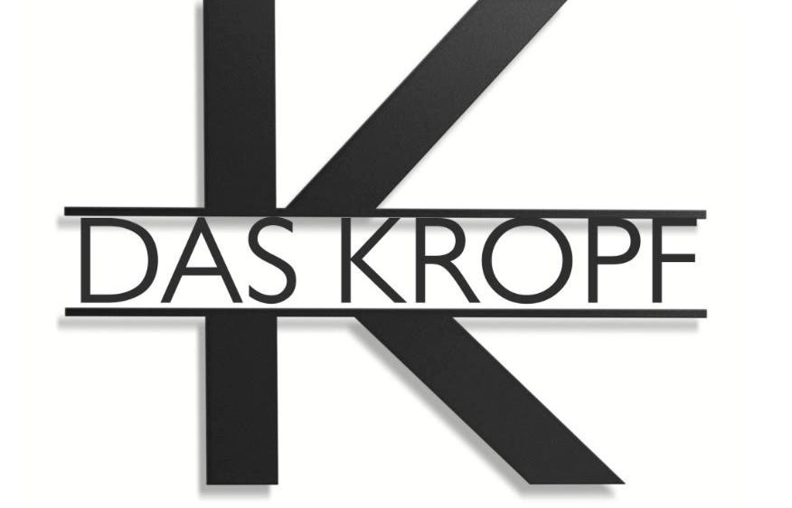 Das Logo für 'Das Kropf' ist auf weißem Hintergrund dargestellt. Es zeigt ein stilisiertes 'K' in Schwarz, mit dem Wort 'DAS' darüber und 'KROPF' darunter, was ein zusammenhängendes Design bildet.