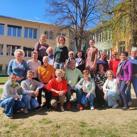 Gruppenfoto der 4. Klasse vor einem Schulgebäude mit einigen Bäumen im Hintergrund.