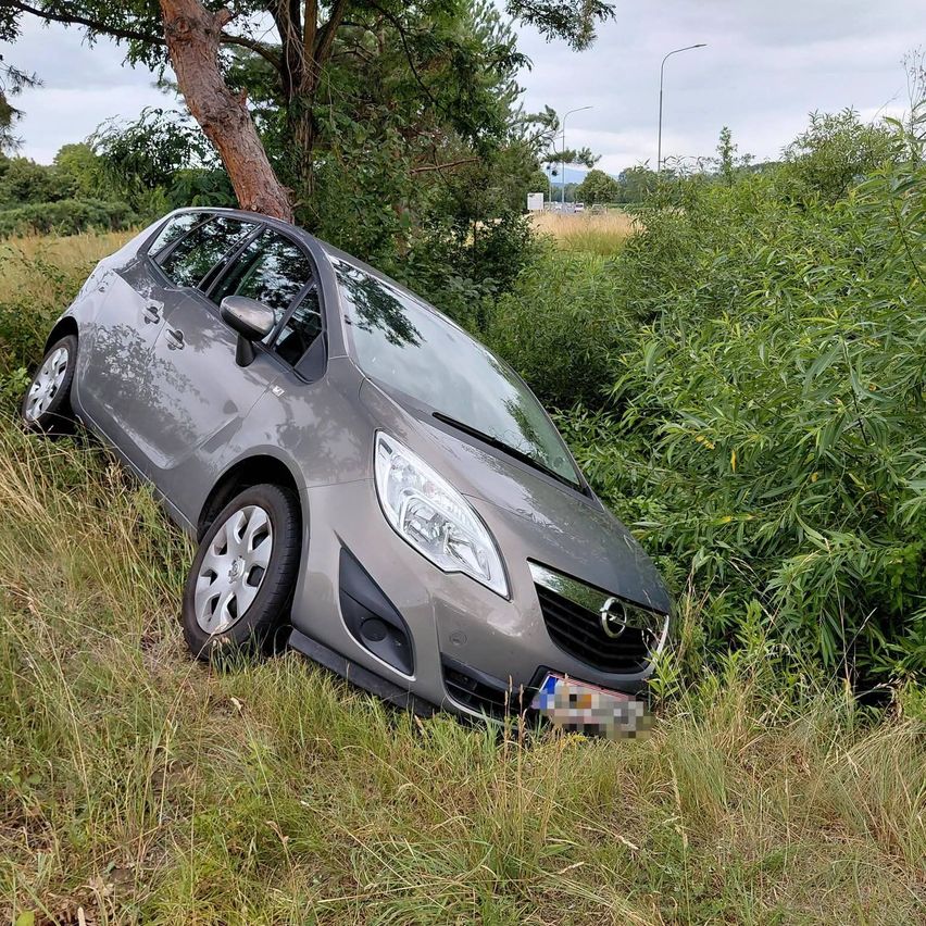 Ein grauer Opel-Wagen steckt im Gras in der Nähe eines Baumes. Das Auto scheint von der Straße abgefahren zu sein.