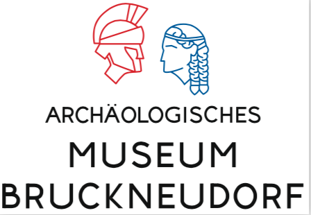 Das Logo des Archäologischen Museums Bruckneudorf zeigt eine rote Illustration eines gehelmten Mannes und eine blaue Illustration einer Frau mit geflochtenen Haaren. Der Text lautet 'ARCHAOLOGISCHES MUSEUM BRUCKNEUDORF'.