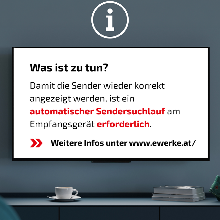 A monitor displays a message in German about an automatic sender search being necessary for correct sender display. A cup and books are on the desk below.