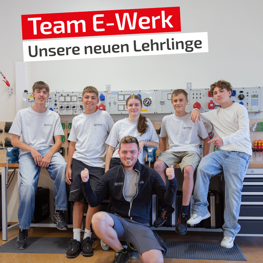 Fünf junge Personen, vier Jungen und ein Mädchen, posieren für ein Foto in einer Werkstatt. Sie tragen alle weiße T-Shirts und Jeans. Der Mann in der Mitte kniet und gibt einen Daumen hoch.