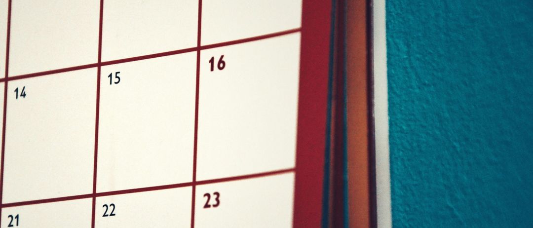 Ein Nahaufnahme eines weißen Kalenders zeigt die Tage 8, 15, 16, 22 und 23. Der Kalender hat rote Linien, die die Tage trennen.