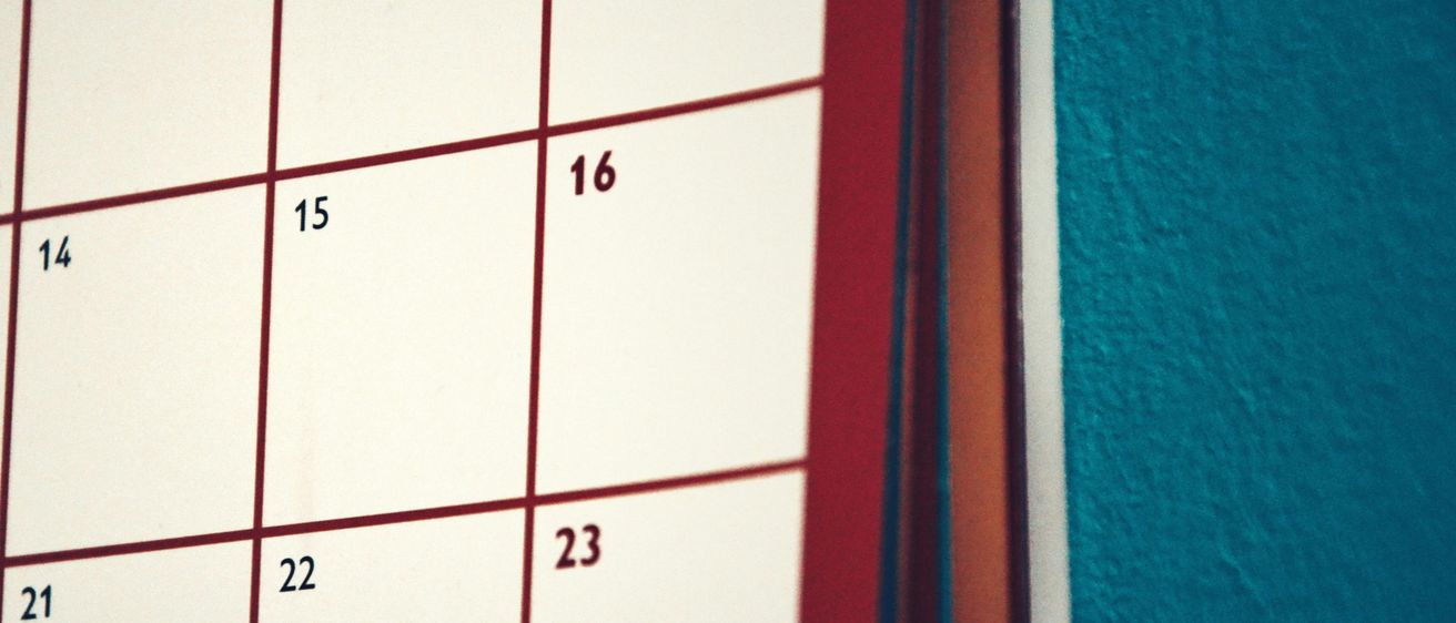 Ein Nahaufnahme eines weißen Kalenders zeigt die Tage 8, 15, 16, 22 und 23. Der Kalender hat rote Linien, die die Tage trennen.