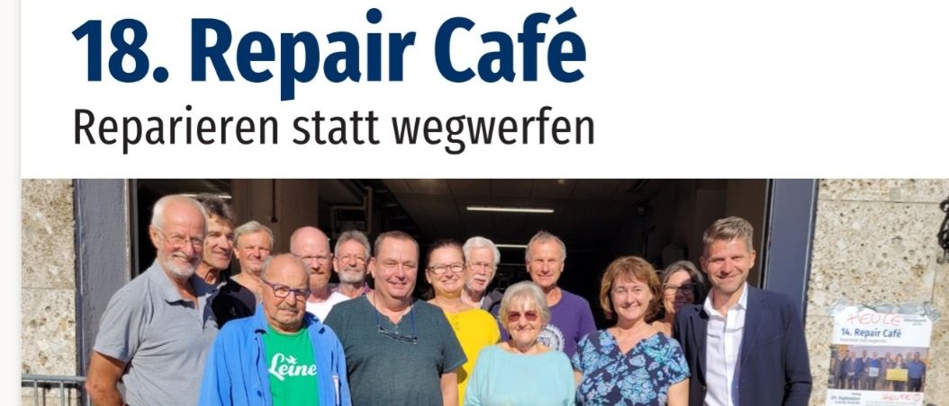 Eine Gruppe von Menschen steht zusammen vor einem Gebäude und lächelt für ein Foto. Der Text auf dem Plakat lautet '18. Repair Café' und 'Repair Café bedeutet Zusammenkommen beim Kaffee und Austausch von Kompetenzen, Fachmeinungen und Anfragen rund um das Reparieren.' Datum und Uhrzeit sind ebenfalls angegeben.