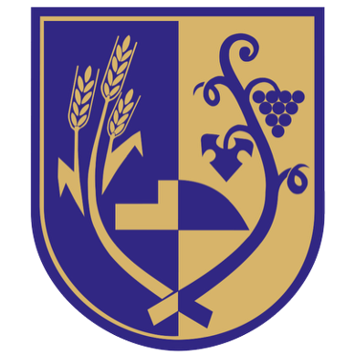 Ein Schild, der in vier Abschnitte unterteilt ist, jeder mit verschiedenen Symbolen, einschließlich Weizen, Trauben und einem Kreuz. Der Schild ist blau und gold.