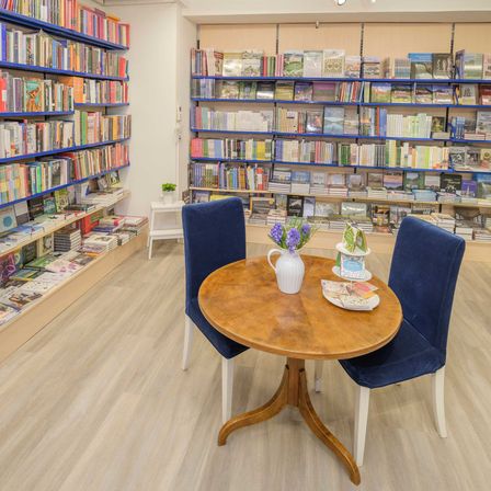 Bild enthält, Book, Indoors, Library, Publication, Furniture, Chair, Shop, Bookcase, Person, Plant