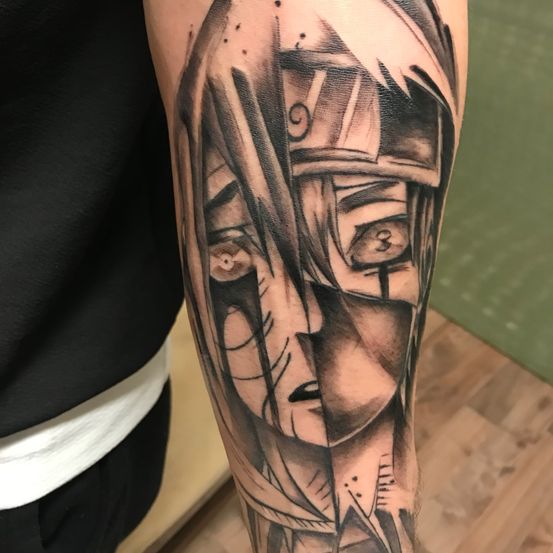 Ein detailliertes schwarzes und graues Anime-Charakter-Tattoo befindet sich am Oberarm einer Person. Der Charakter hat langes Haar und einen Helm. Die Zahlen 3 und 9 sind ebenfalls auf dem Tattoo sichtbar.