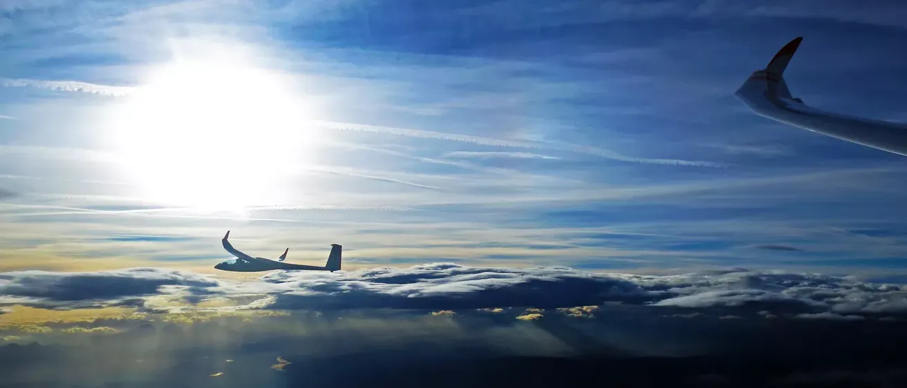 Ein Flugzeug fliegt an einem sonnigen Tag über den Wolken.