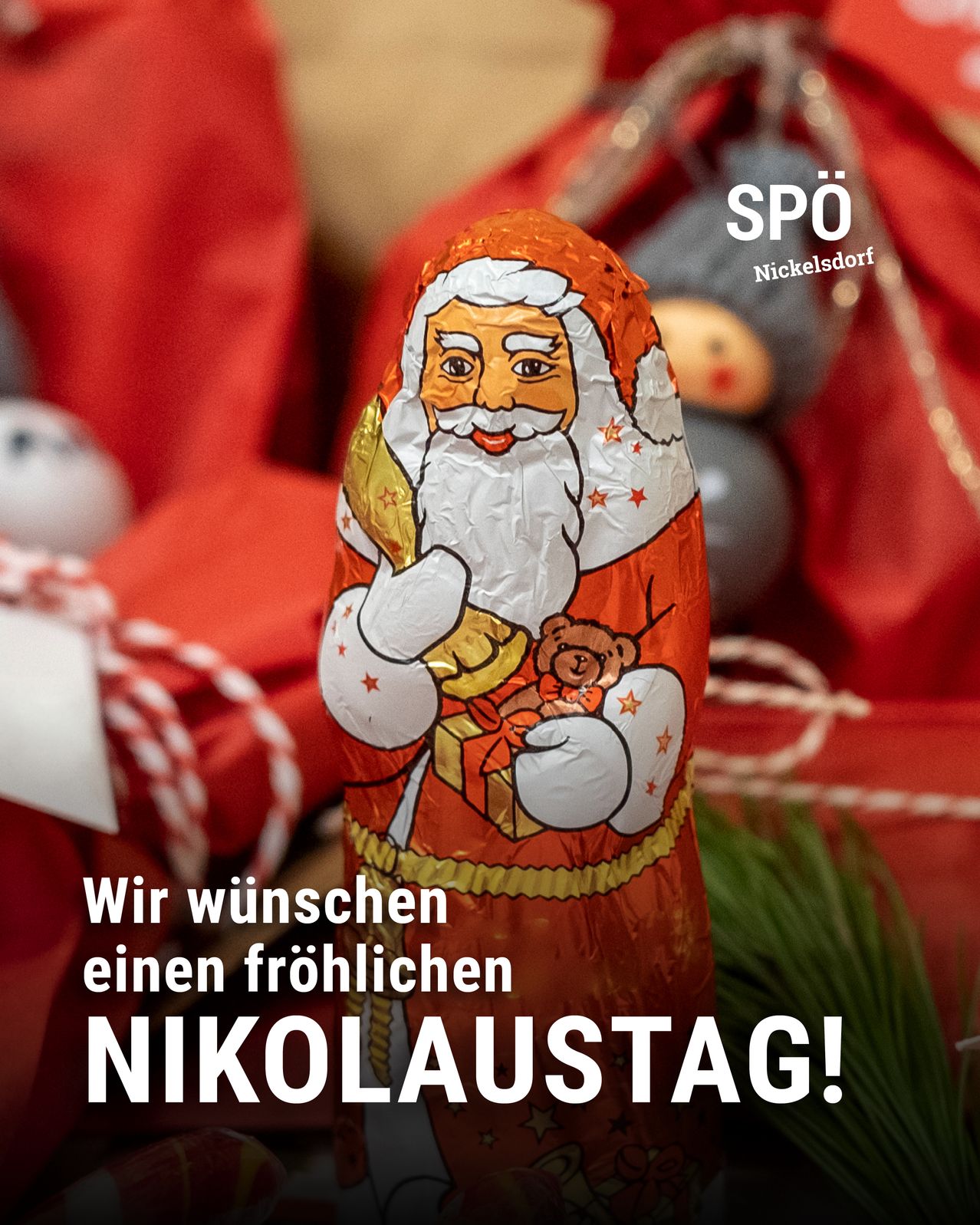 Eine Schokoladenfigur von Santa Claus ist zu sehen, die ein Geschenk und einen Teddybär hält. Die Worte 'Wir wuenschen einen froehlichen NIKOLAUSTTAG!' sind angezeigt. Ein festlicher Hintergrund ist rot.
