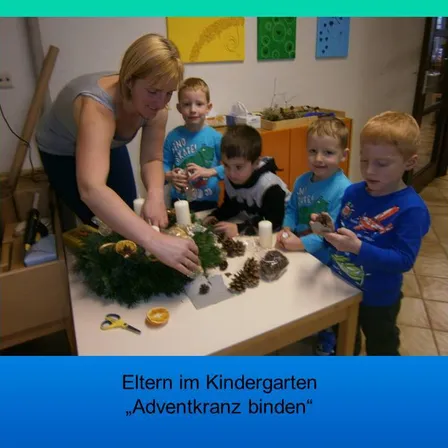 Eine Frau und vier junge Jungen versammeln sich um einen Tisch und stellen einen Kranz aus Tannenzapfen und Kerzen her. Die Frau hält einen Tannenzapfen und platziert ihn auf dem Kranz. Die Jungen beobachten und halten Tannenzapfen. Das Bild hat einen Wasserzeichen mit dem Text 'Eltern im Kindergarten Adventkranz binden'.