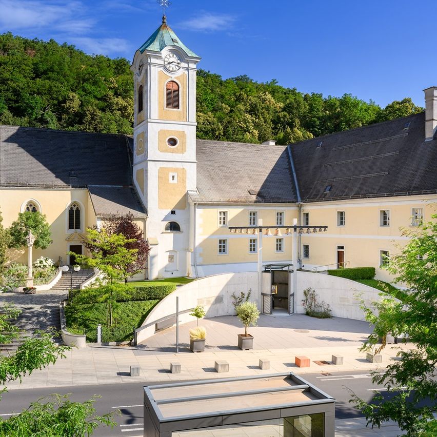 Luftaufnahme der St. Georg Kirche mit Glockenturm, Glasüberdachung und umgebender Grünfläche.