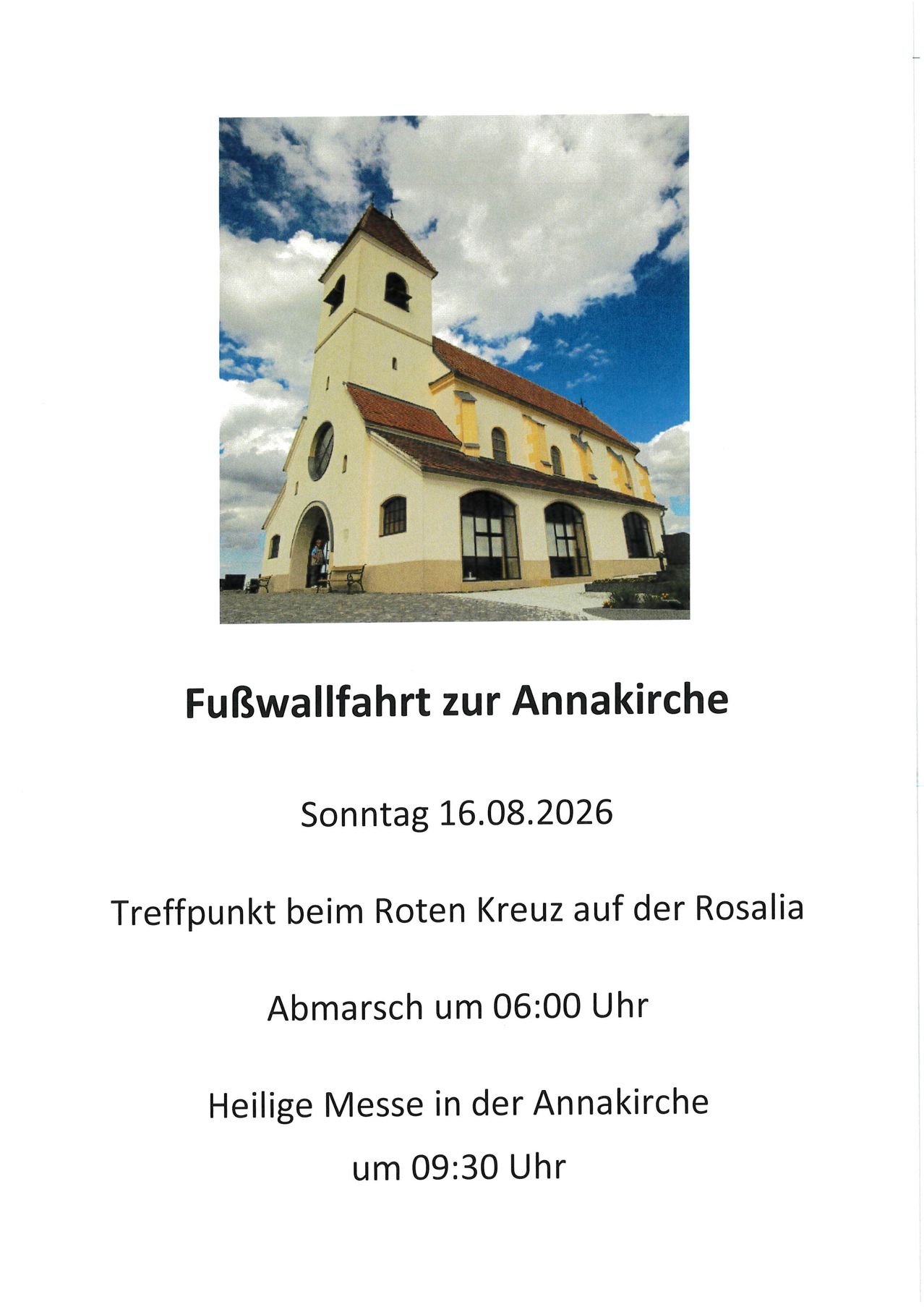 Eine Kirche mit Glockenturm und rotem Dach, umgeben von einem bewölkten Himmel. Die Kirche heißt Annakirche.
