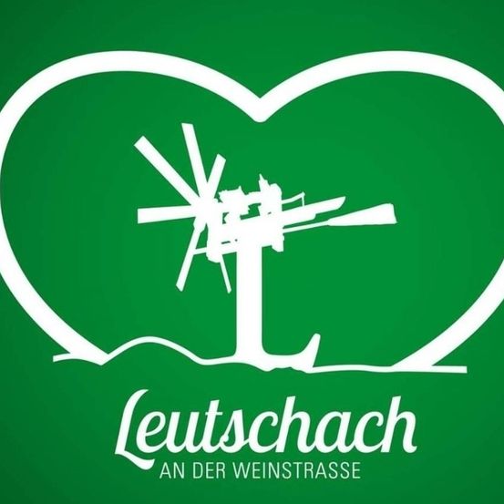 Ein Werbeplakat fur Lerutschach an der Weinstrasse zeigt ein Herz mit einem Windrad und Baum darin, vor einem grunen Hintergrund.