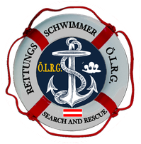 Das Emblem zeigt einen Anker in der Mitte, umgeben von der Aufschrift 'O.L.R.G. Suche und Rettung'. Das Emblem befindet sich in einem roten und weißen Rettungsring.