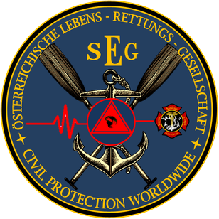 Das SEG-Emblem hat einen blauen Hintergrund mit einem Anker, gekreuzten Rudern und einem roten Dreieck. Die Worte 'CIVIL PROTECTION WORLDWIDE' sind in Gelb geschrieben. Das Emblem enthält auch eine Herzfrequenzlinie und einen roten Stern.