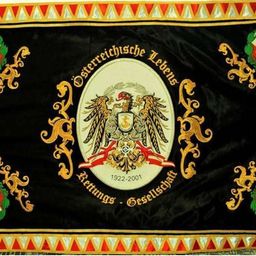 Ein schwarz-goldenes Tuch zeigt ein zentrales Emblem mit Adler, Schild und Lorbeerkranz. Umgeben ist das Emblem von dekorativen Elementen. Die Jahre 1922 und 2001 sind zu sehen, mit zusätzlichem Text in Deutsch.
