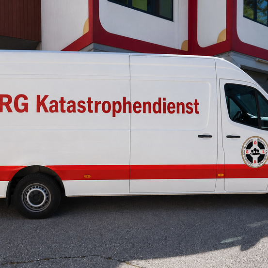 Ein weißer Lieferwagen mit roten Schriftzug 'RG Katastrophendienist' parkt an der Straßenseite vor einem Gebäude.