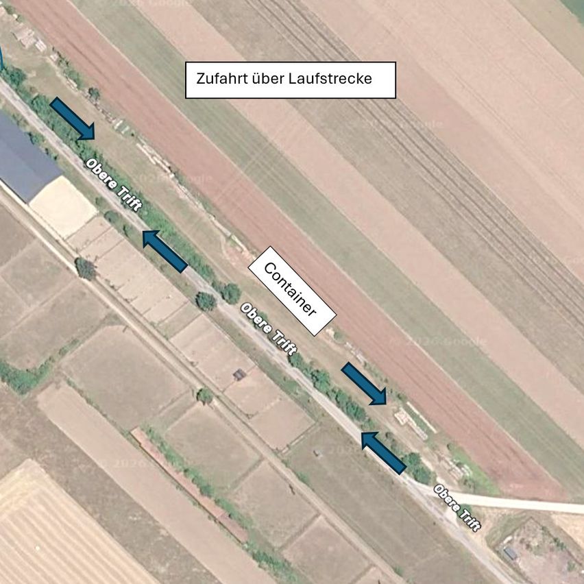 Luftaufnahme eines ländlichen Gebiets mit Straßen, die mit 'Obere Trift' und 'Container' beschriftet sind. Pfeile zeigen die Fahrtrichtungen auf asphaltierten Straßen an. Das Gebiet ist von Feldern umgeben und hat einen klaren Himmel.