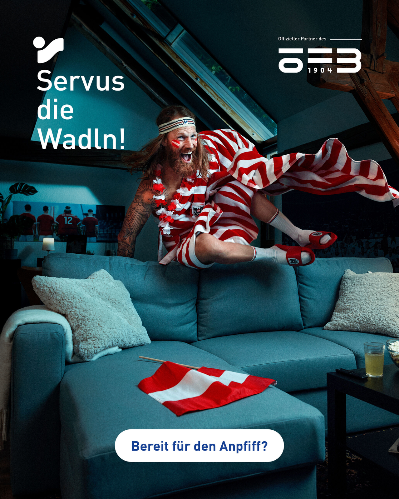 Ein Mann in einem rot-weiß gestreiften Kostüm springt über ein Sofa, mit einer Flagge als Umhang. Eine Schweizer Flagge liegt auf dem Sofa.