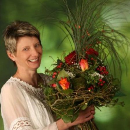 Bild enthält, Face, Happy, Head, Person, Smile, Flower, Flower Arrangement, Flower Bouquet, Plant, Potted Plant
