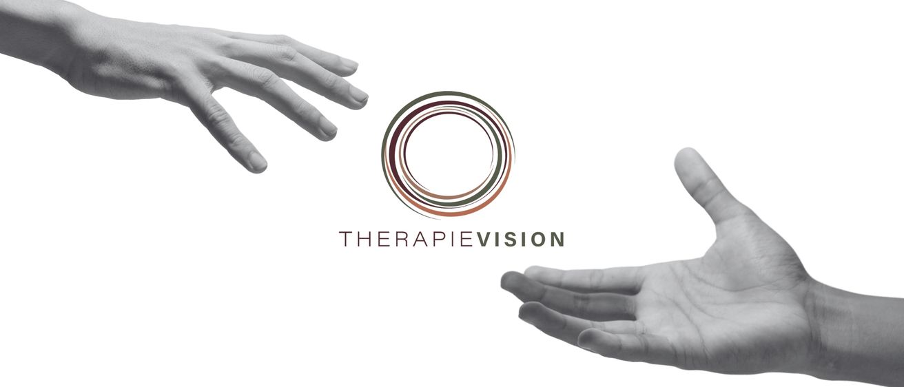 Schwarz-Weiß-Bild zeigt zwei Hände, die sich einem Kreis-Logo nähern, das 'THERAPIEVISION' lautet. Die Hände und das Logo sind in Schwarz-Weiß.