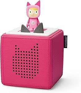 Ein rosafarbener würfelförmiger Lautsprecher mit weißer Oberseite und einer rosa Figur oben. Der Lautsprecher hat ein Muster kleiner Löcher.