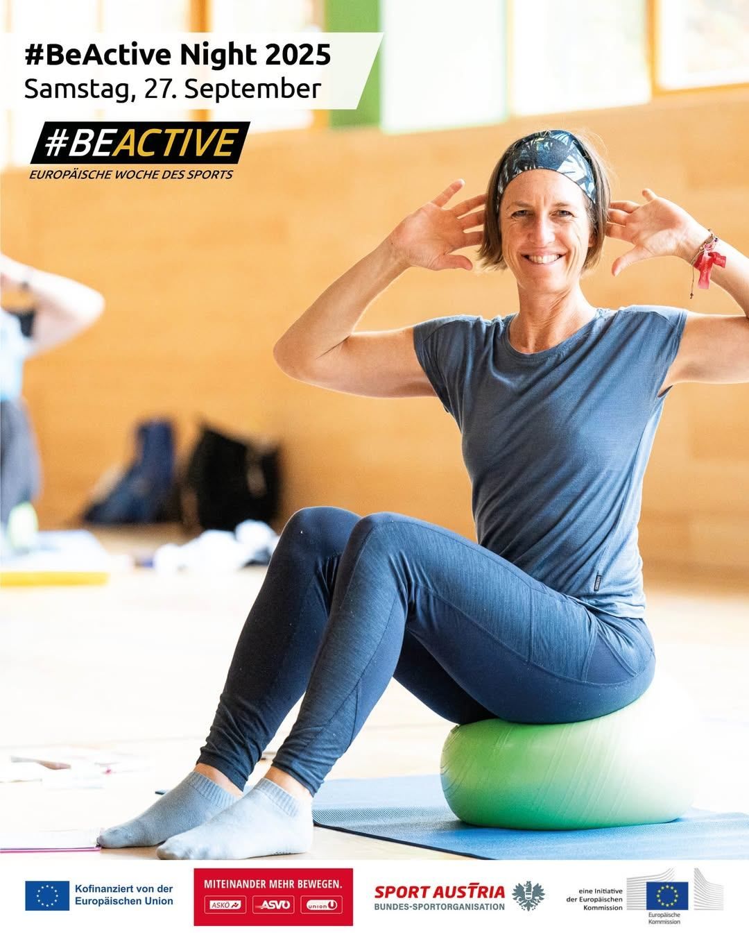 Eine Frau sitzt auf einem grünen Gymnastikball, trägt eine Stirnband und lächelt für ein Foto. Sie hat ihre Hände auf dem Kopf und es gibt einen Wasserzeichen mit dem Text '#BEACTIVE' oben links.
