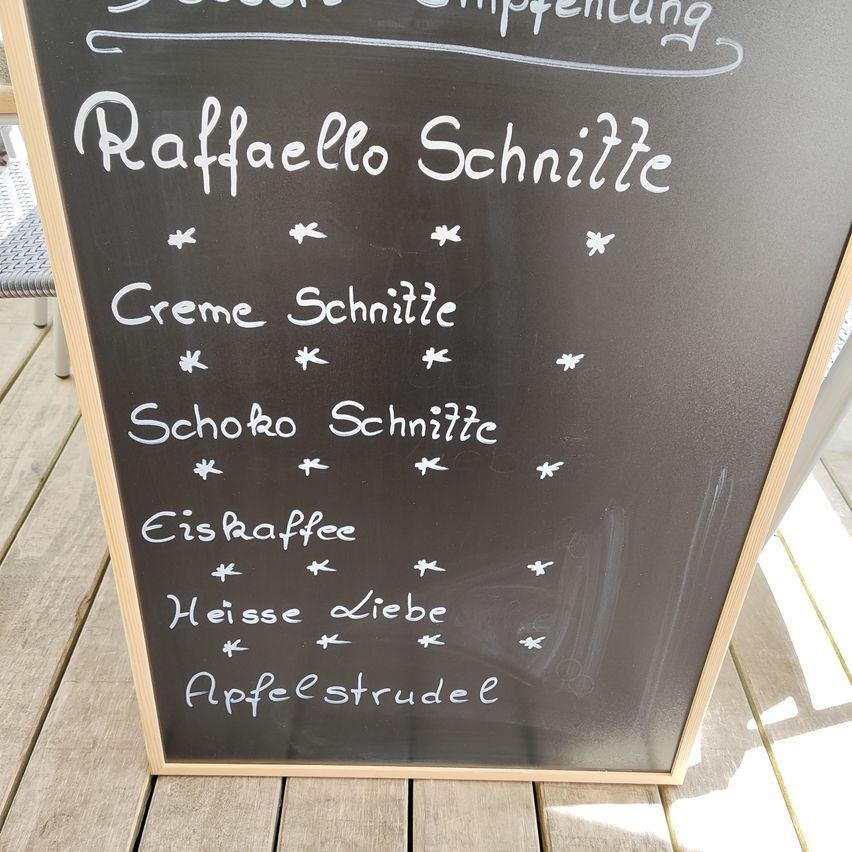 Ein schwarzes Kreidetafel-Menü mit Raffaello Schnitzel, Creme Schnitzel, Schoko Schnitzel, Eiskaffee, Heisse Liebe und Apfelstrudel.