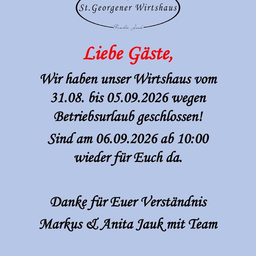 Ein blaues Plakat verkündet, dass das St. Georgener Wirtshaus vom 31.08. bis 05.09.2026 wegen Betriebsurlaub geschlossen ist. Es öffnet am 06.09.2026 um 10:00 Uhr wieder. Die Nachricht ist von Markus und Anita Jauk mit Team unterzeichnet.
