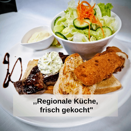 Ein Teller mit gegrilltem Fleisch, einer Salatschüssel mit Gurke und Karotten und gebratenem Brot, begleitet von einer cremigen Dip und einer Soßendrizzle.