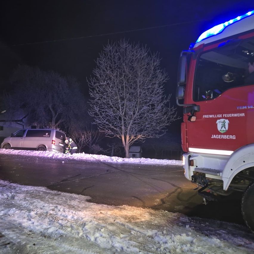 A van has crashed into a tree, with firefighters responding on a snowy night.