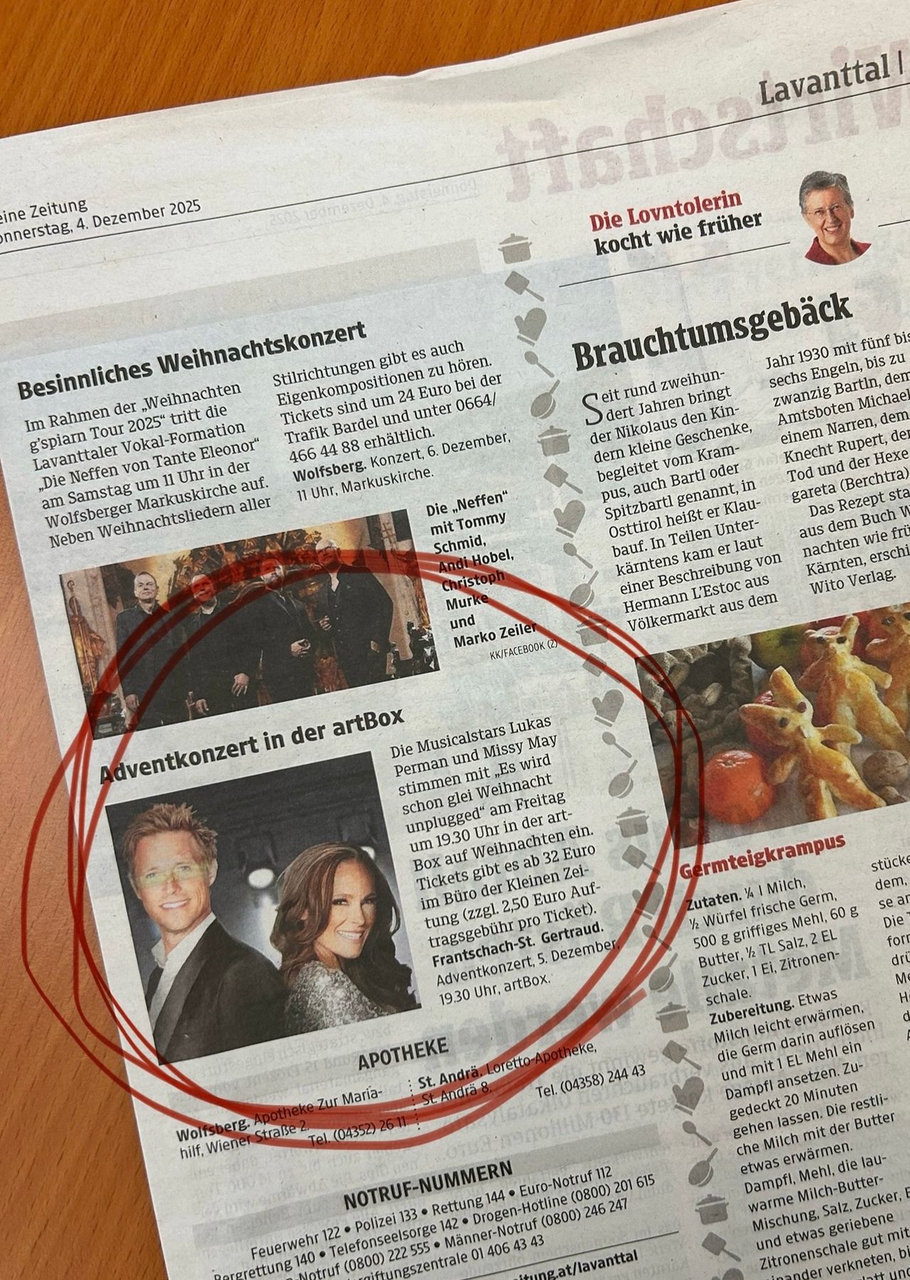 Eine Zeitung zeigt ein Foto von zwei Personen mit einem roten Kreis darum. Der Artikel handelt von einem Weihnachtskonzert. Es wird ein Ticketpreis von 24 Euro erwähnt. Das Konzert findet am 6. Dezember statt.