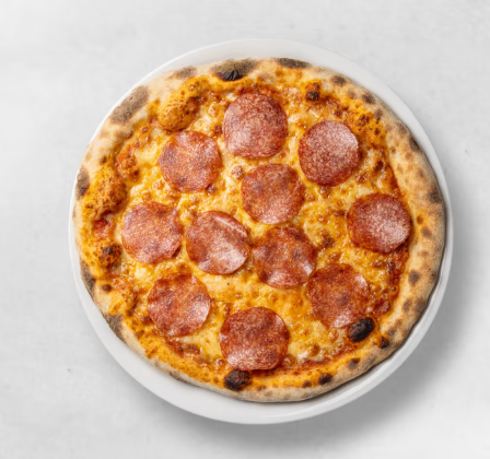 Eine frisch gebackene Pepperoni-Pizza auf einem weißen Teller vor weißem Hintergrund.