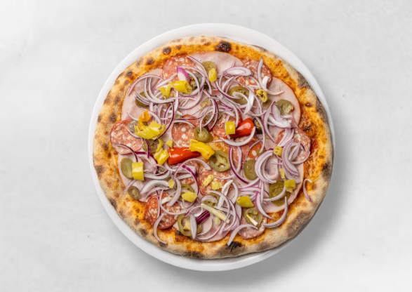 Eine Pizza mit Zwiebeln, Paprika, Oliven und Salami liegt auf einem weißen Teller vor einem schlichten Hintergrund.