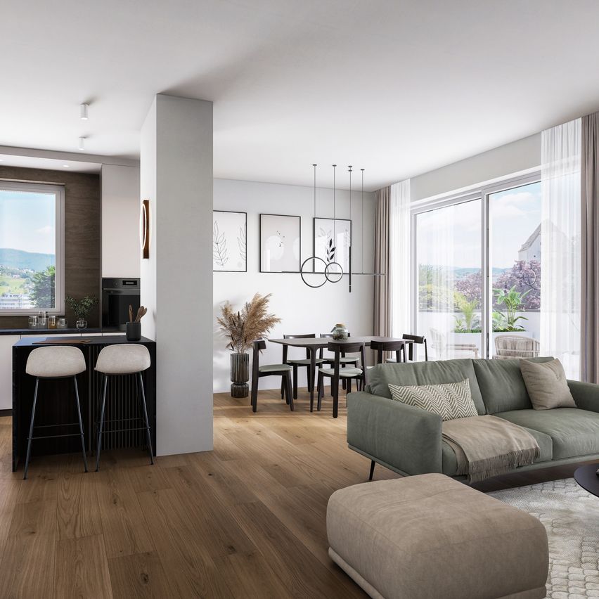 Modern living room with a kitchen area, dining table, and sofa with pillows. It has wooden floors, large windows, and a view of the mountains.