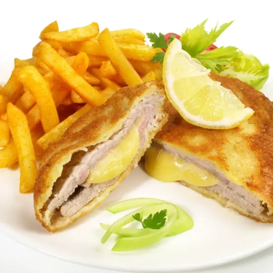 Ein Teller mit einer gebratenen Hähnchenschnitzel mit geschmolzenem Käse, einer Zitronenscheibe und Pommes frites.