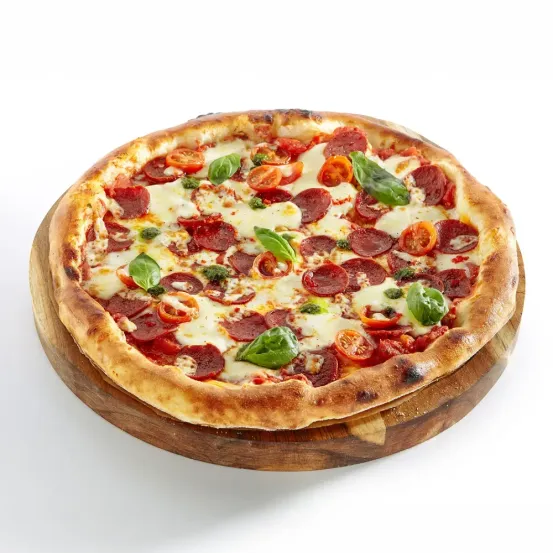 Eine ganze Pepperoni-Pizza mit weißem Käse, roten Pepperoni und Basilikumblättern auf einem Holzbrett.
