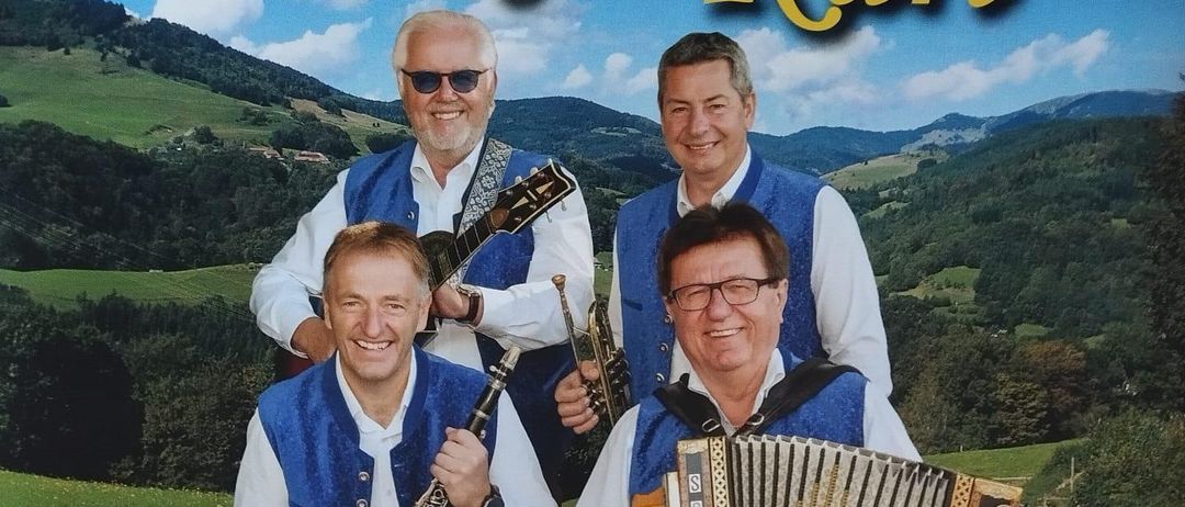 Plakat für die Leutschach-Veranstaltung am 23. Mai um 13 Uhr, mit vier Musikern in traditioneller Kleidung, die verschiedene Instrumente halten, vor einem grünen Hintergrund.