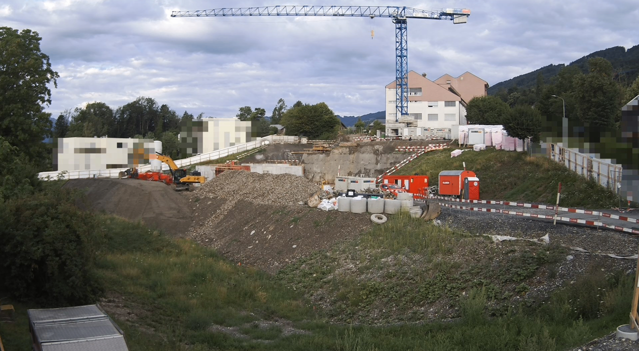 A construction site with a large crane, various machinery, and a partially built building.