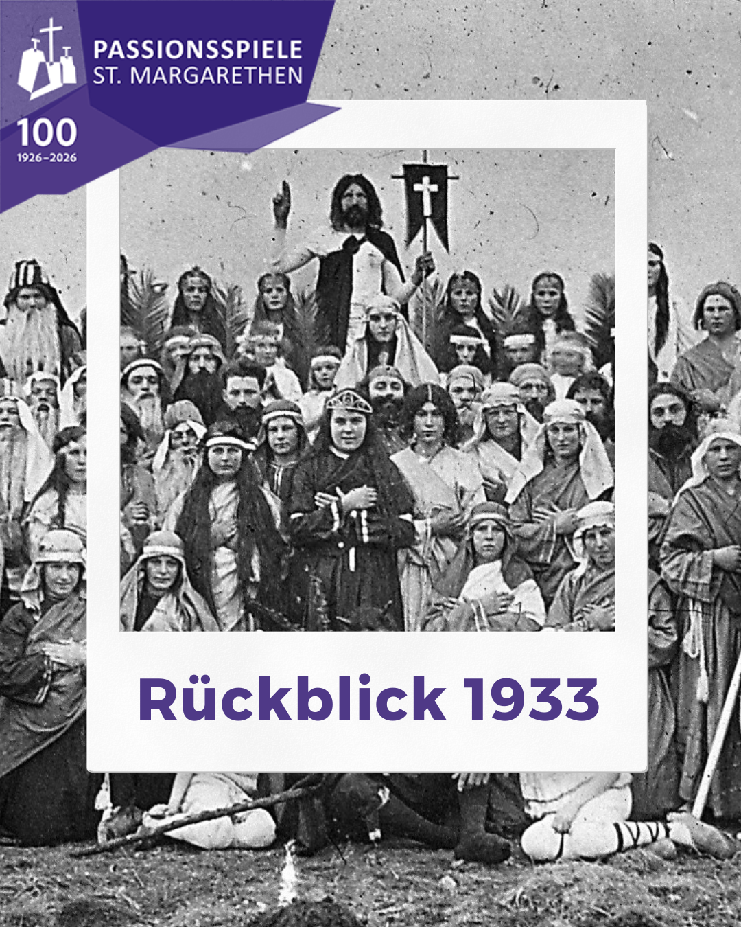 Ein Schwarz-Weiß-Foto aus dem Jahr 1933 zeigt eine Menschenmenge in historischen Kostümen. Ein Mann in der Mitte hält ein Kreuz und deutet mit seiner Hand. Das Foto hat einen Rand mit dem Text '100 1926-2026' und 'Ruckblick 1933' unten.