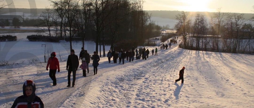 Verschneiter Weg mit mehreren Menschen, die gehen, bereit für ein friedliches Treffen am 20.12.2025 um 15:00 Uhr, beginnend am Hauptplatz Oberpullendorf.
