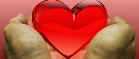 A pair of hands holds a translucent red heart against a pink background. The heart appears to be melting, symbolizing deep emotions.