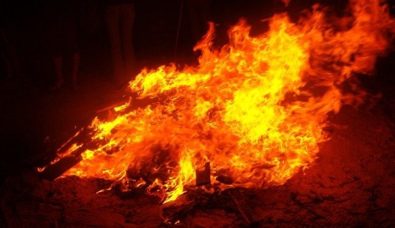 Ein Lagerfeuer brennt nachts hell und wirft ein warmes Licht. Es knackt intensiv heiß.